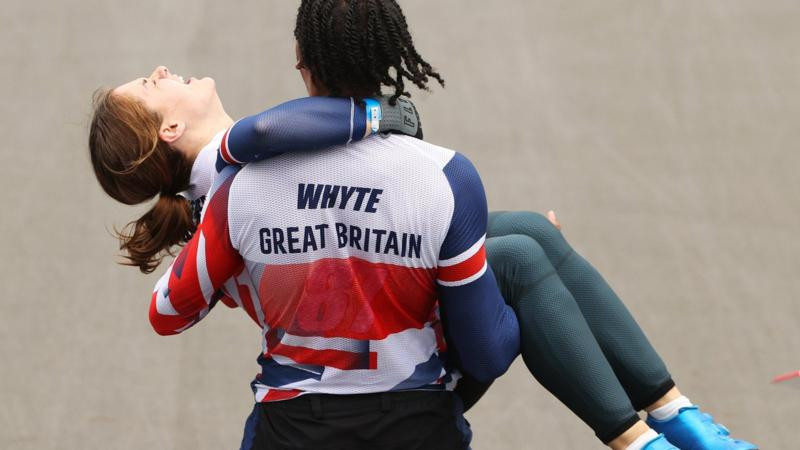 7-р сарын 30: Их Британийн тамирчин Бетани Шриеверыг алтан медаль хүртсэний дараа “Team GB” багийн хамтаргч Kye Whyte өргөж яваа нь