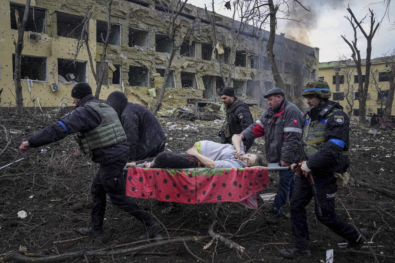 Украины онцгой байдлын ажилтнууд Мариуполь хотын амаржих газарт бэртсэн жирэмсэн эмэгтэйг зөөвөрлөж байжээ (Evgeniy Maloletka/AP)