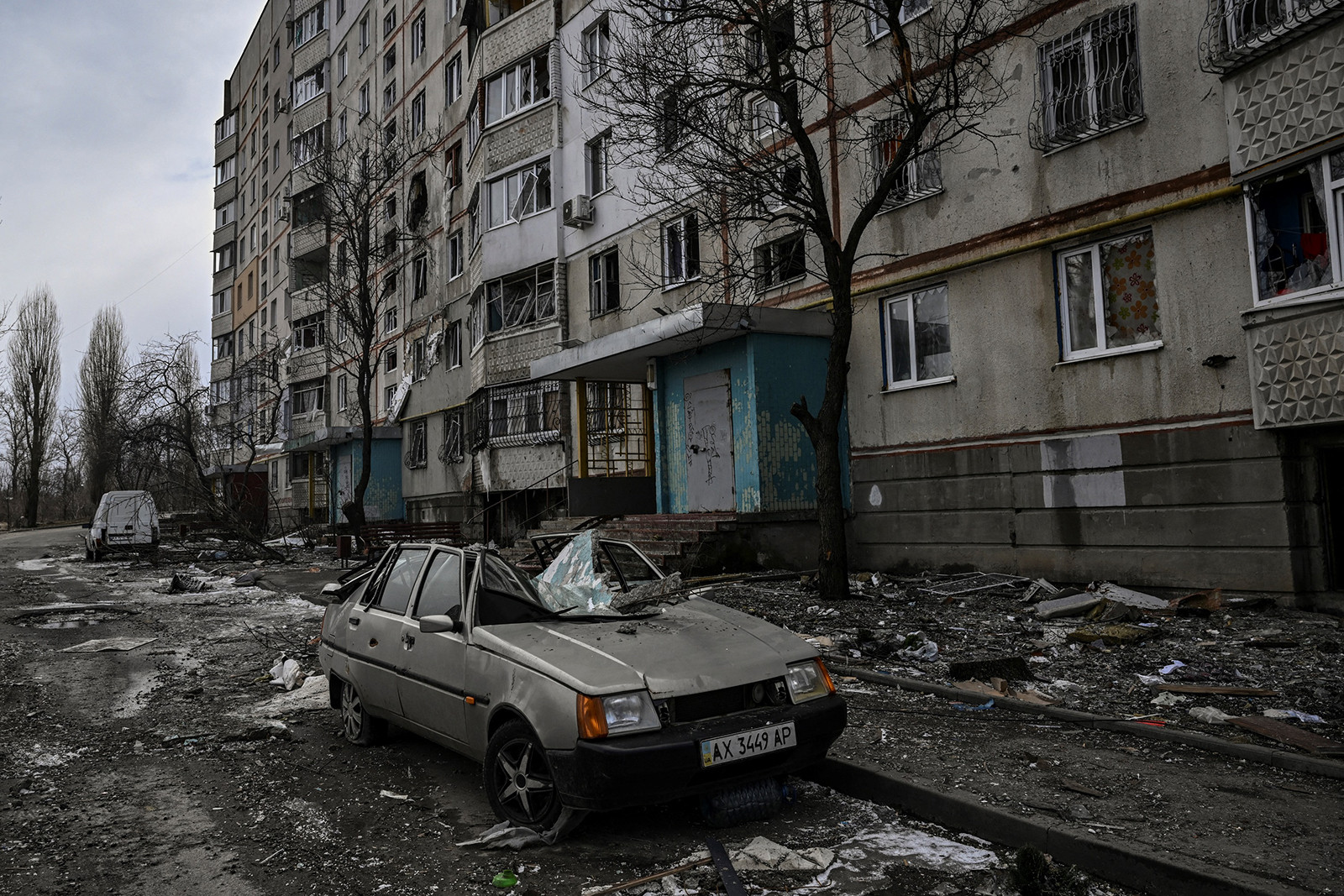 Гуравдугаар сарын 27-нд Харьков хотын сүйрсэн орон сууцны ойролцоо эвдэрсэн автомашин харагдаж байна.  (Aris Messinis/AFP/Getty Images)
